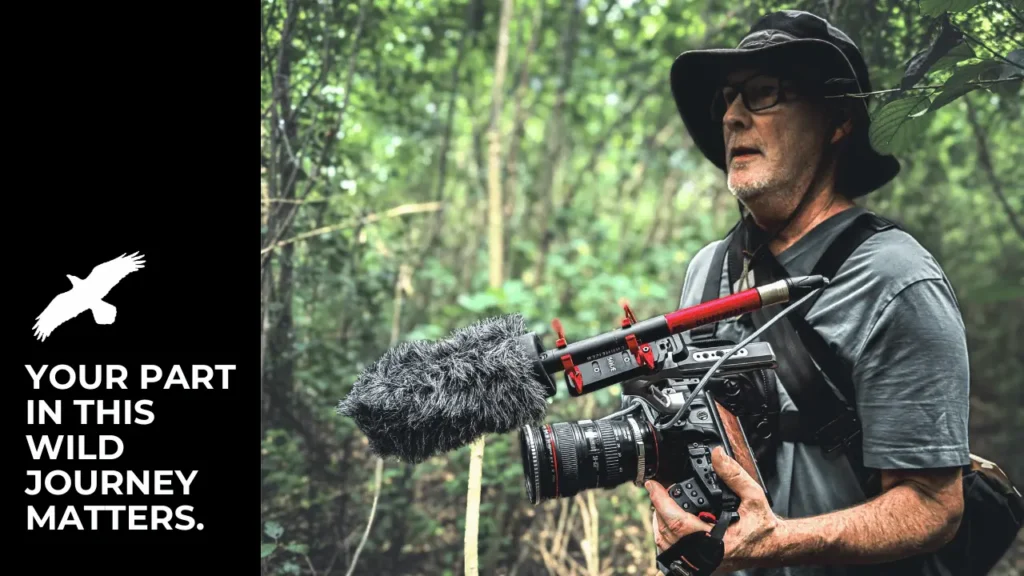 Gregg McLachlan holding a cinema camera, ready to capture wildlife and conservation stories, with space on the left for inspirational text inviting organizations to join the documentary journey.
